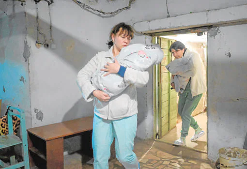 Enfermeras con bebes en brazos, mientras huyen al sótano, en la maternidad de Mykolaiv