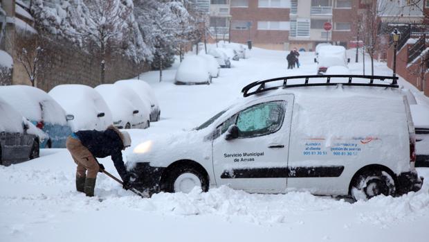 La nevada caída durante las últimas 24 horas ha causado numerosos problemas en la capital abulense, que ha amanecido con una capa de nieve de entre 30 y 40 centímetros, por lo que dieciséis personas en tránsito han tenido que ser refugiadas en las dependencias de la Policía Local. En la imagen, un hombre retira la nieve de su vehículo con ayuda de una pala.