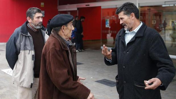 José Carlos Giménez (d), el padre del interno de la prisión de Asturias al que los médicos dieron por muerto y que recobró ayer el conocimiento después de trasladarle al Instituto Anatómico Forense para practicarle la autopsia, conversa con familiares, esta tarde en la entrada del Hospital Universitario Central de Asturias (HUCA)