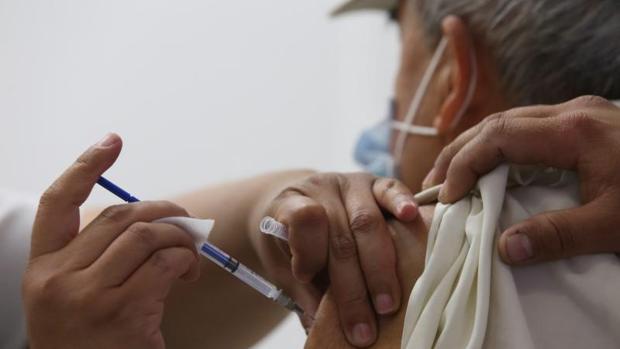 Una persona mayor recibe la vacuna de la gripe en un centro de salud