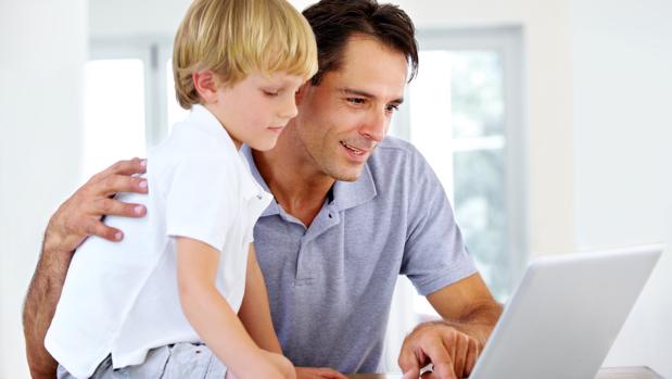 Un hombre consulta internet junto a su hijo
