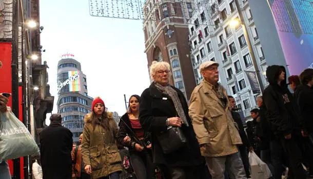 Ancianos caminando en pleno centro de Madrid, abarrotado estos días por la marabunta de personas buscando regalos y compras navideñas