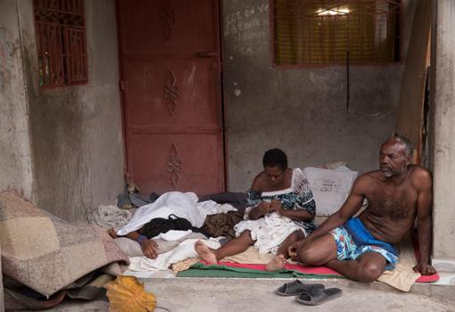 Noel (derecha) y su familia descansan en la entrada de su casa, en Les Cayes (Haití), tras el terremoto registrado el sábado pasado