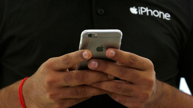 Una persona muestra un terminal iPhone
