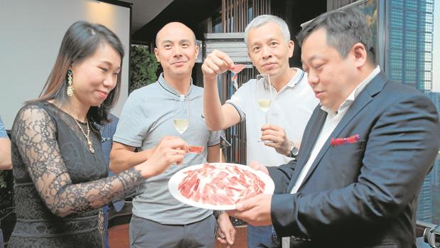 Clientes chinos degustan jamón ibérico en una cena en el hotel Gran Hyatt de Cantón (Guangzhou), elaborada por Alexandre Mazzia (abajo, con camisa negra), chef francés con estrella Michelin